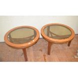 A pair of coffee tables, with glass inset tops and curved stretchers, 81.5 cm diameter