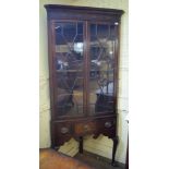 An 18th century style corner cupboard on stand, having a pair of bar glazed doors, the stand on