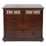 A late 17th/early 18th century oak chest, having four graduated long drawers, the top drawer