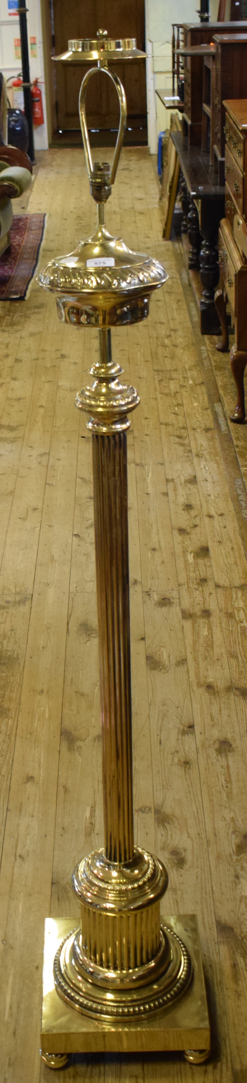 A late 19th/early 20th century brass standard lamp, with a reeded column, adapted for electricity,