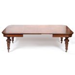 An early Victorian mahogany extending dining table, inset two extra leaves, on carved and tapering