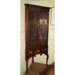 An 18th century style corner cupboard on stand, having a pair of bar glazed doors, the stand on