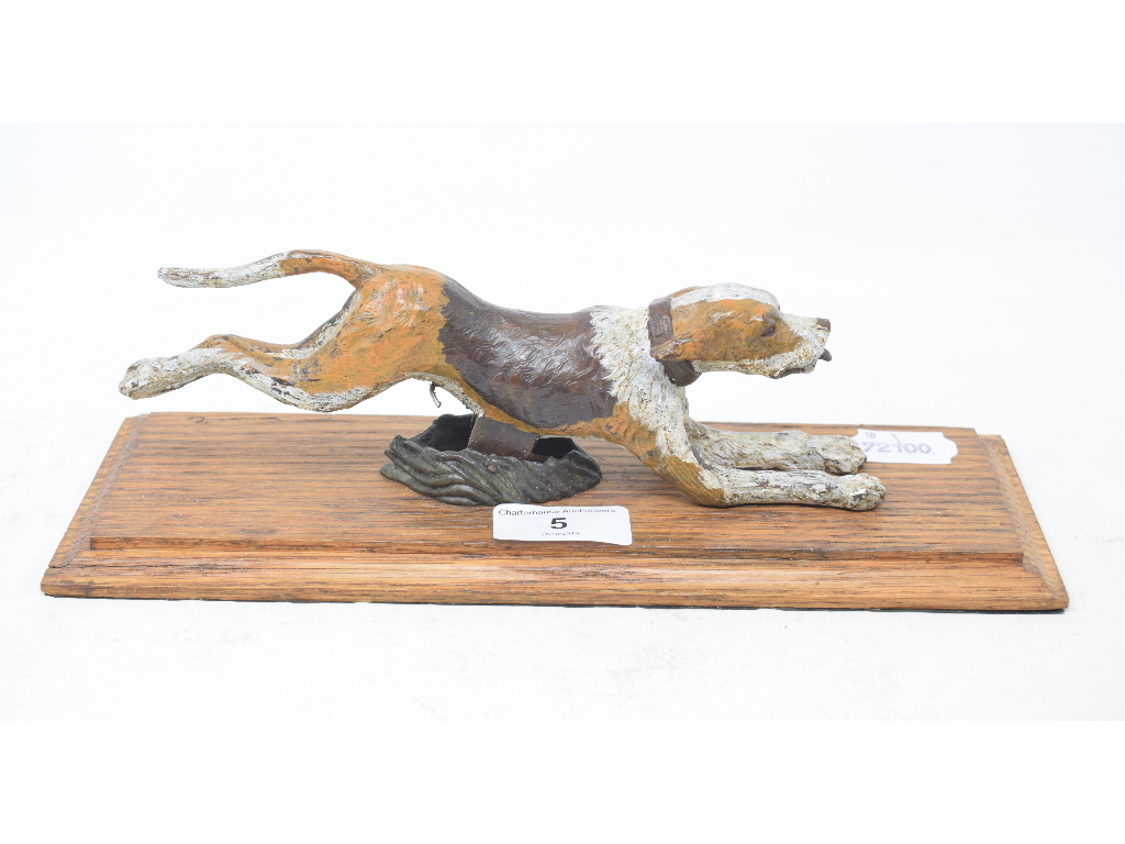 A novelty painted bronze running hound paperclip, on a wooden base, 27.5 cm wide Modern