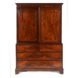 A George III mahogany linen press, the moulded and dentil cornice above a pair of panel doors,