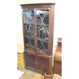 A 19th century floor standing mahogany corner cabinet, having a pair of bar glazed doors above a