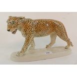 A Continental pottery figure, of a walking leopard, on a rounded rectangular base, 33 cm wide
