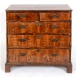 A George III chest, veneered in walnut, having two short and three graduated long drawers, on