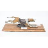 A novelty painted bronze running hound paperclip, on a wooden base, 27.5 cm wide