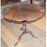 A mahogany tripod table, with a piecrust top, a fluted and reeded vase turned column and leaf carved