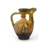 A Canakkle earthenware ewer, with sgraffito incised decoration and a yellow and green graze,