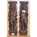 A pair of carved oak caryatids, one man holding a bird, the other a sheath of wheat, 38 cm high (2)