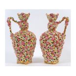 A pair of Zsolnay reticulated vases with handles, decorated flowers and foliage, on four splay