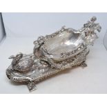 A large silver plated table centrepiece, in the form of a cherub aloft a boat, being pulled by a