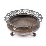 A silver bowl, of compressed circular form, with a pierced border, on three scroll feet, Goldsmith &