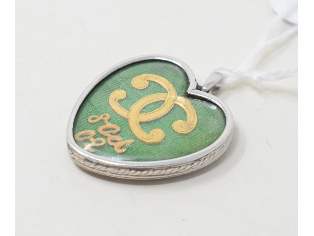 A Cartier heart shaped locket, one side with entwined C's and 8 Oct 02, the other with green