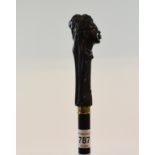 An ebony walking cane, the handle in the form of an African Moorish lady, with glass eyes, 96 cm