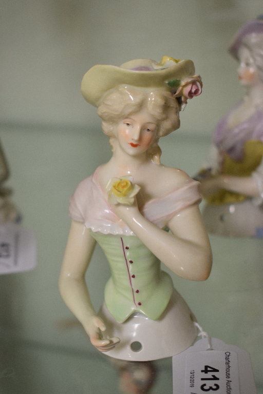 A porcelain half doll, lavender hat and scarf, holding flowers and wearing a yellow corset, 12 cm - Image 2 of 5