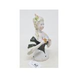 A porcelain half doll, lady wearing a dark green dress, holding a fan, 15 cm high