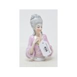 A porcelain half doll, lady with grey ringlets and top knot, in a pink blouse, impressed no. 10015