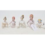 A porcelain half doll, nude female, arms out, 7.5 cm high, and four others (5)