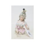 A porcelain half doll, grey hair with flowers and feathers, pink and light blue dress, arms out,