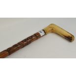 A military themed walking cane, having an L shaped antler handle, the shaft with carved decoration