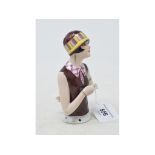 An Art Deco porcelain half doll, lady wearing a brown sleeveless dress and a stripey hat, 12.5 cm