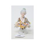 A porcelain half doll, lady with grey hair wearing a brown mottled dress, holding a basket of