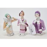 A porcelain half doll, 1920's flapper with purple and lilac cloche hat and coat, 11 cm high, and two