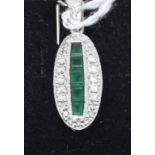 An Art Deco style 18ct white gold, emerald and diamond pendant, of navette form, the emeralds