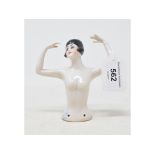 A porcelain half doll, nude lady with black bobbed hair, arms up over her head, 10 cm high