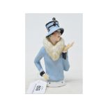 An Art Deco porcelain half doll, 1920's fashion model, wearing a blue fur lined coat and matching