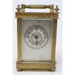 A brass carriage timepiece, having a 4.5 cm diameter silvered Roman numeral dial, the case with