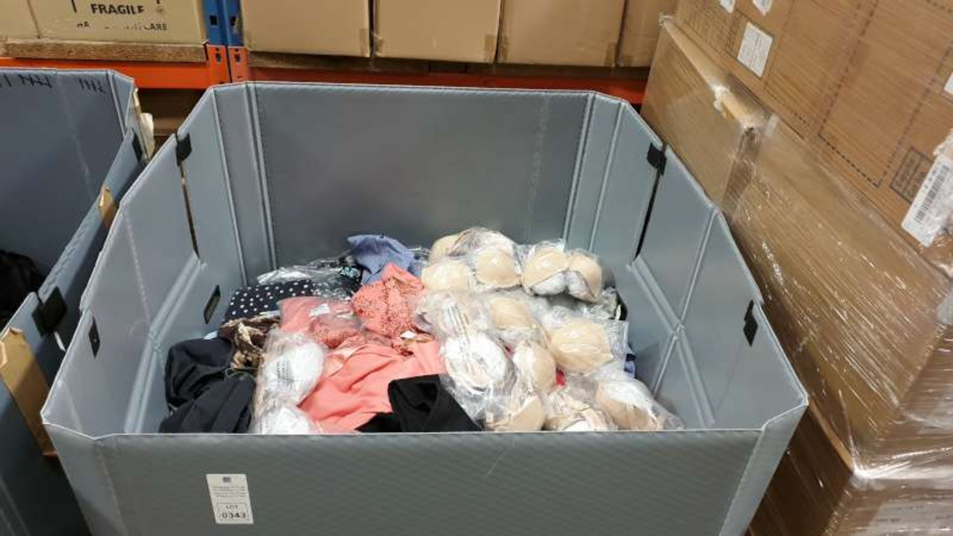 PALLET BOX CONTAININNG A LARGE QTY OF CLOTHING IN VARIOUS COLOURS STYLES AND SIZES