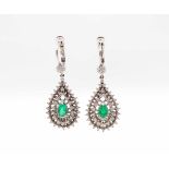1 pair of earrings in 750 white gold with one emerald and various diamonds each, total ca. 0,60 ct.