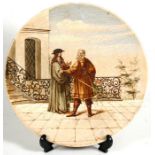 A German porcelain hand painted wall plate depicting two gentlemen in discussion in a courtyard,