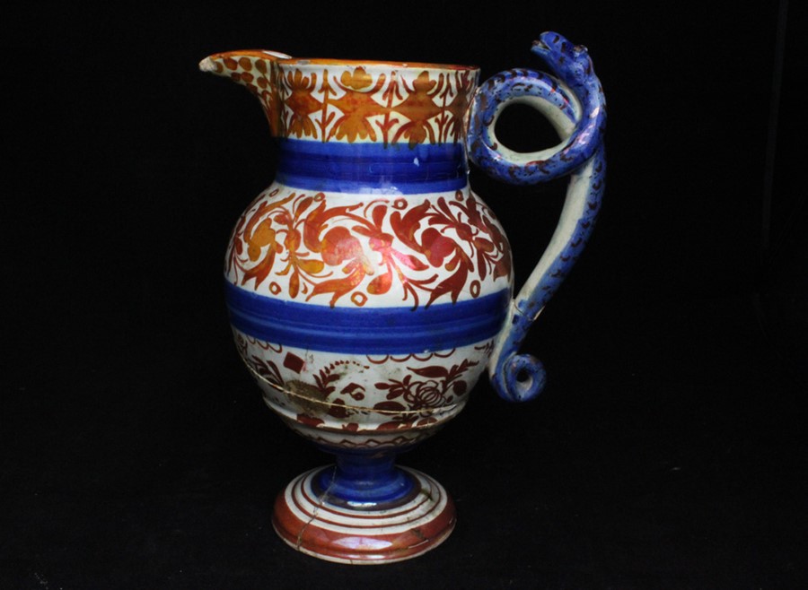 An 18th / 19th century copper lustre jug decorated flowers, with coiled serpent handle, 27cms (10.