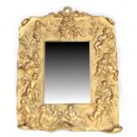 A 19th century gilt metal repousse easel backed mirror decorated with winged cherubs and a reclining