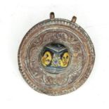 A Romanesque bronze pendant set with a millefleur glass cabochon depicting two faces, 5cms (2ins)