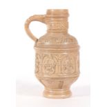A German stoneware jug decorated with figures and heraldic crests, 22cms (8.5ins) high.