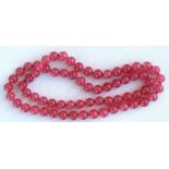 A Chinese pink glass bead necklace.