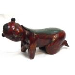 A Chinese polychrome and lacquer carved wooden head rest or pillow in the form of a kneeling boy,