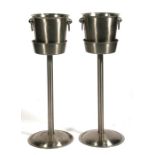 A pair of stainless steel ice buckets on stands, 69cms (27ins) high.