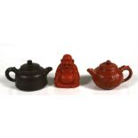 Two Chinese Yixing pottery teapots; together with a Yixing figure in the form of a seated Buddha (