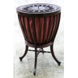 An Edwardian mahogany sewing basket with silk liner, standing on a quatrefoil base.