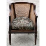 A 19th century mahogany bergere tub chair on turned front supports.Condition Reportthe seat board is
