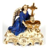 A 19th century continental porcelain holy water font depicting an angel and crucifix, 24cms (9.5ins)