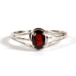 A 9ct white gold dress ring set with a single oval garnet, approx UK size 'S'.