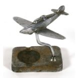 A chrome plated model of a WW2 fighter mounted on an ashtray base. Wingspan 14cms (5.5ins)