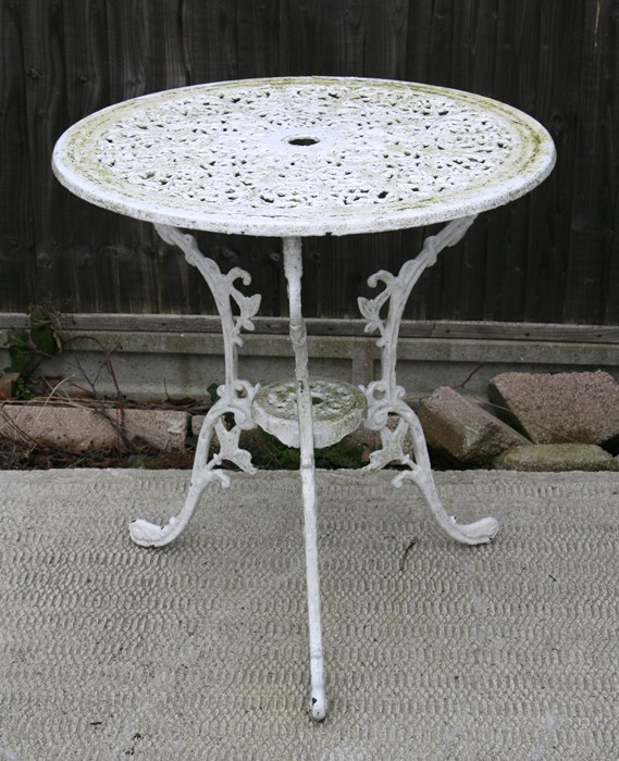 A cast pierced and painted aluminium garden table, 69cms (27ins) diameter.